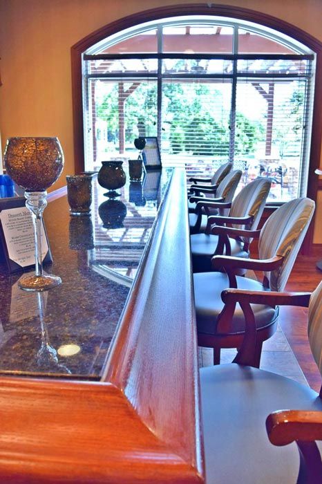 A cozy bar area with seating and glassware, overlooking a window view.