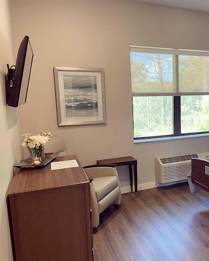 A serene waiting room featuring a comfortable chair, modern furniture, and calming artwork.