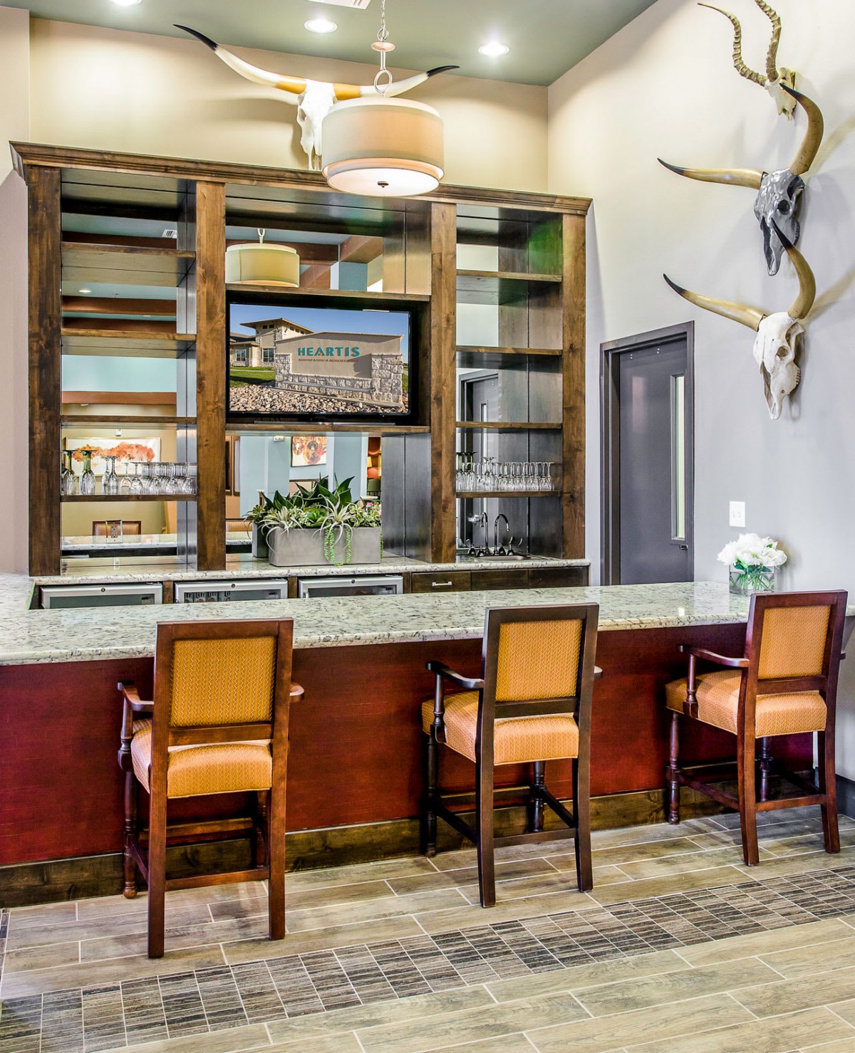 A modern reception area with a desk, three chairs, and decorative elements on the wall.