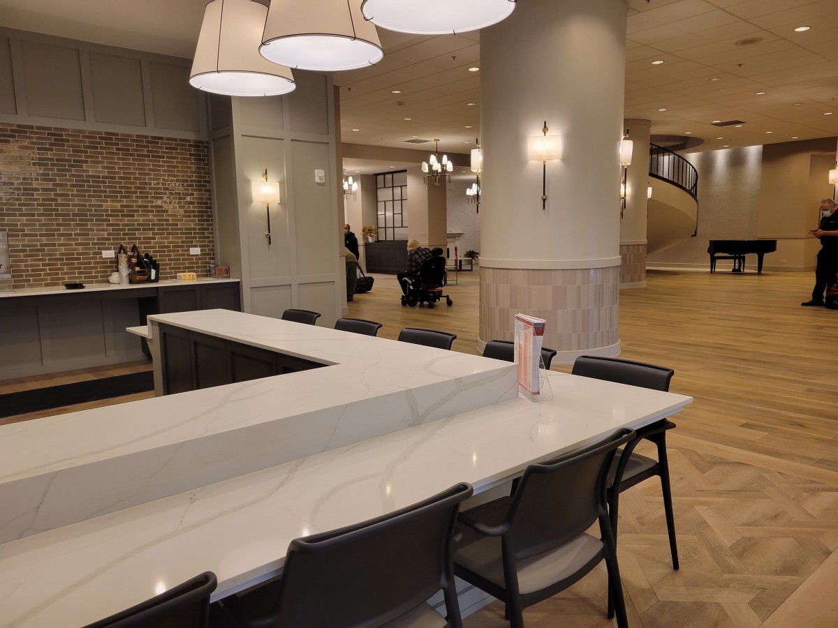 A modern lounge area with a marble table, comfortable seating, and stylish lighting fixtures.