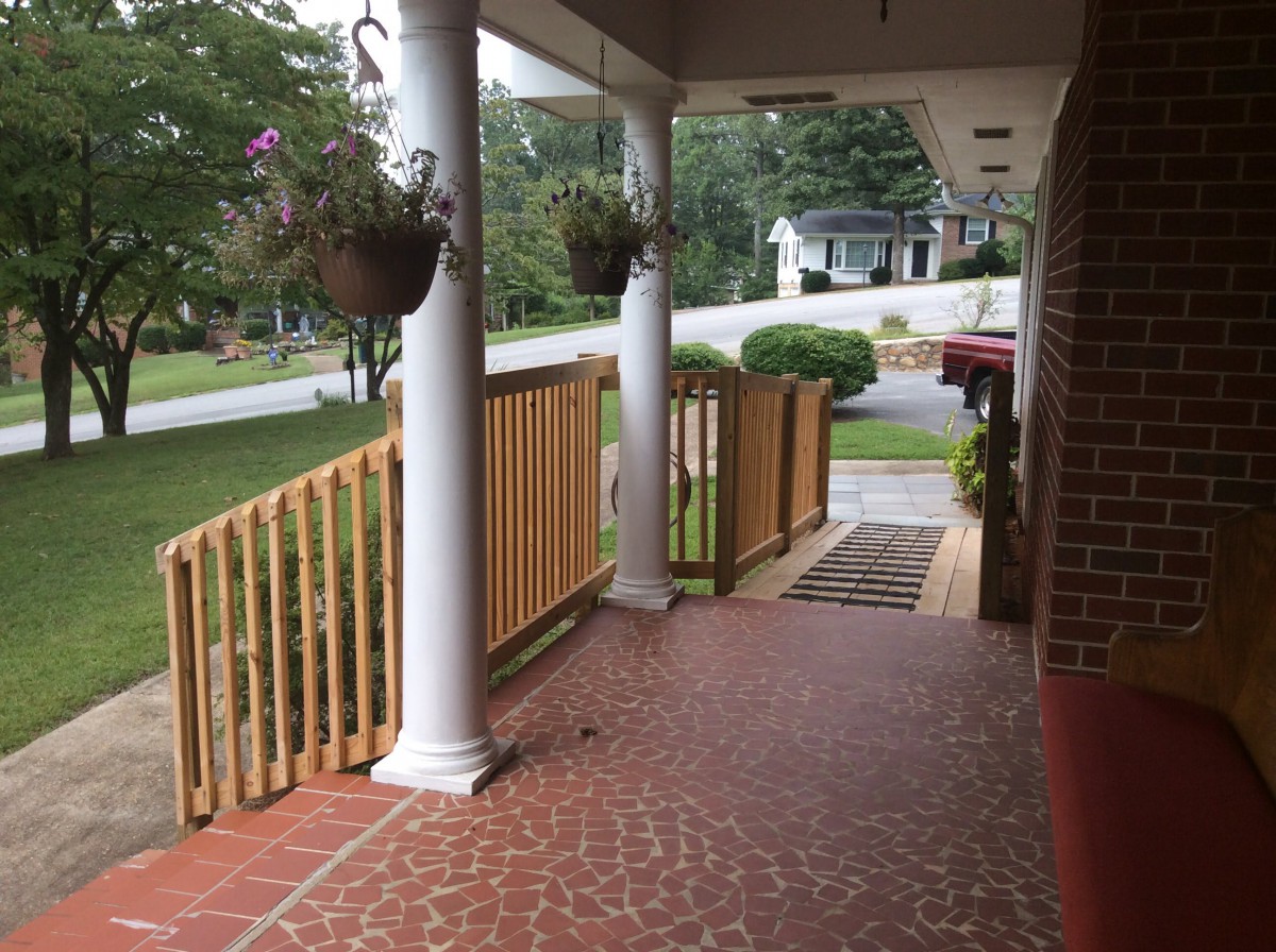 A view from the porch overlooking a garden and surrounding neighborhood.