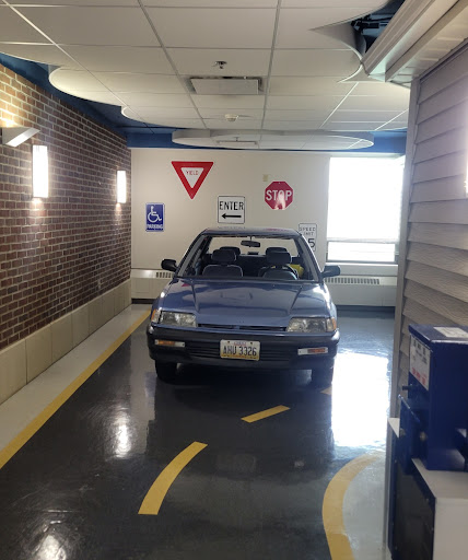 A blue car parked indoors near traffic signs.