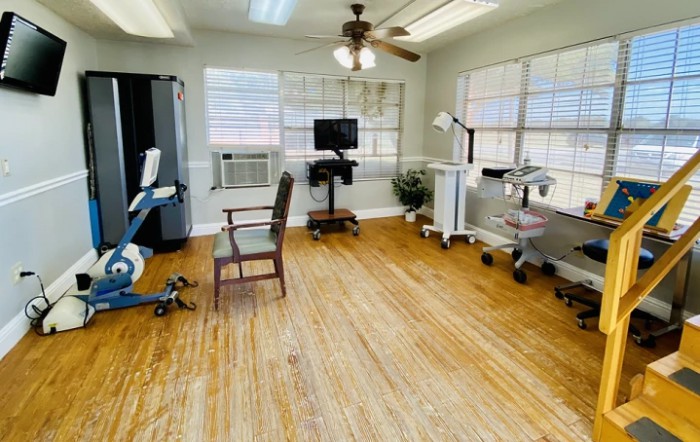 A clean and organized medical office with various equipment and wooden flooring.