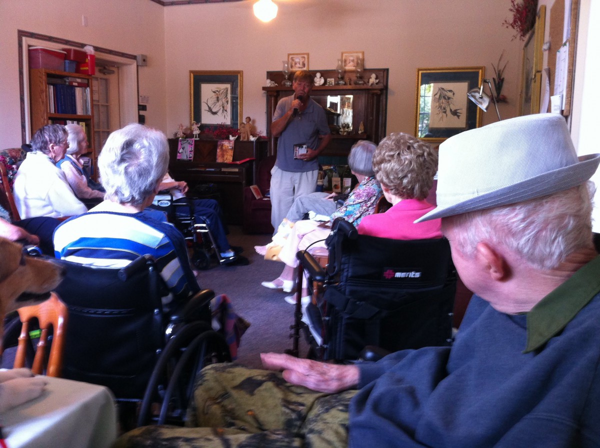 A group of elderly people in wheelchairs gathered indoors, engaged in a community activity.