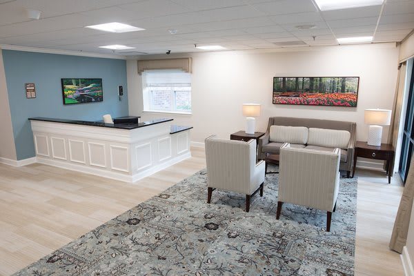 A modern office reception area with a desk and comfortable seating arrangement.