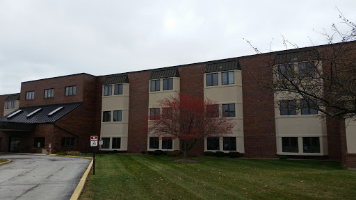 A residential apartment building showcasing a brick facade and well-maintained lawn.