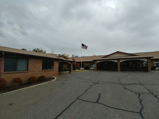 A view of a residential building with an American flag flying under a cloudy sky.