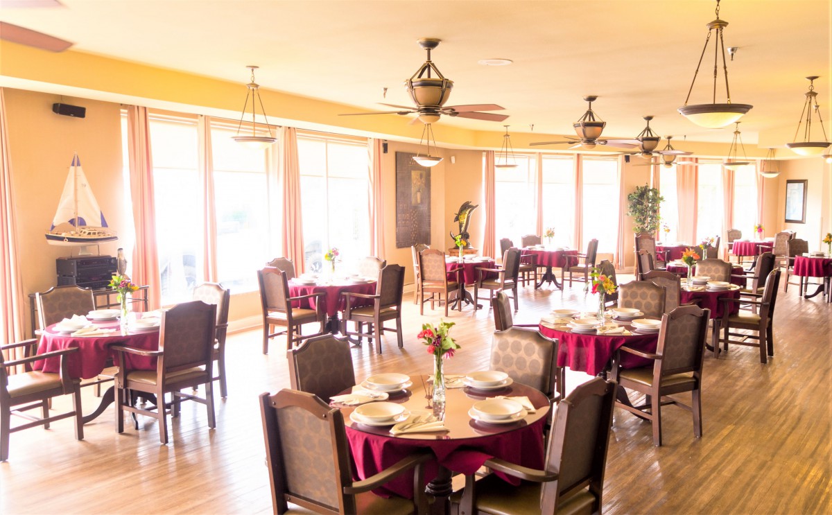 A well-lit restaurant dining area with neatly arranged tables and chairs.