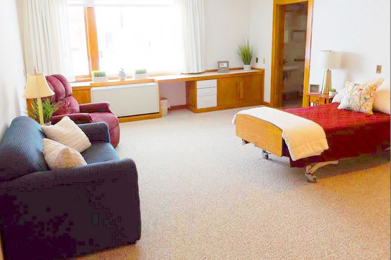 A serene therapy room featuring a comfortable massage table and cozy seating.