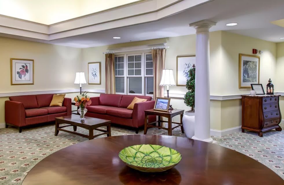 A cozy living room with red sofas, a coffee table, and warm lighting.