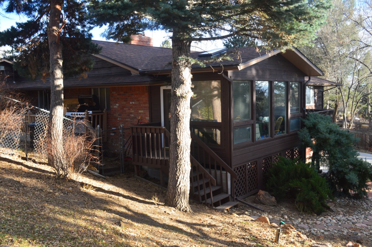 A cozy cabin-like house surrounded by trees with sunlight filtering through.