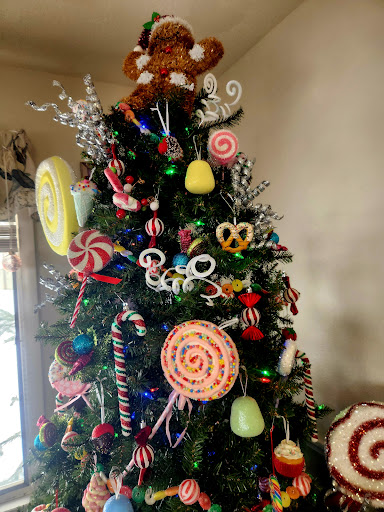 A whimsical Christmas tree adorned with a variety of candy-themed decorations, bringing a sweet touch to the holiday spirit.