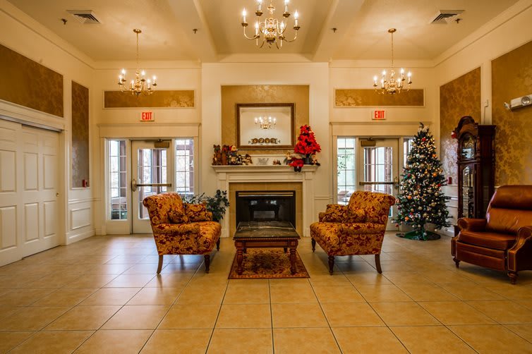 A cozy living room with armchairs, a fireplace, and holiday decorations.