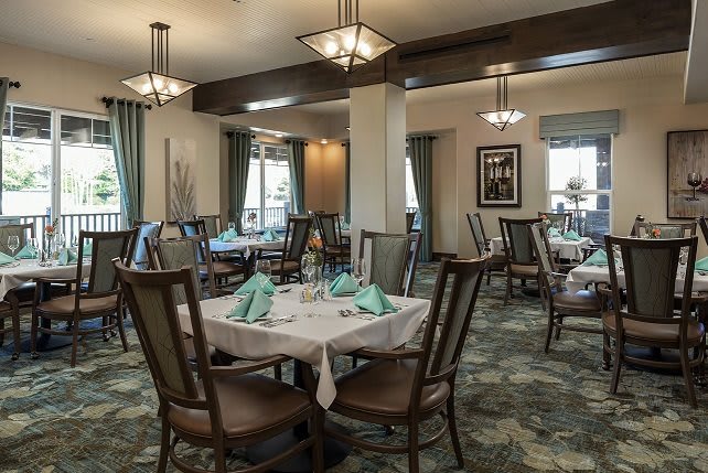 A well-decorated restaurant dining area with neatly set tables and elegant lighting.