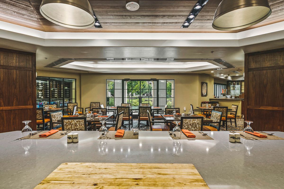 A spacious and modern restaurant dining area with neatly arranged tables and chairs.
