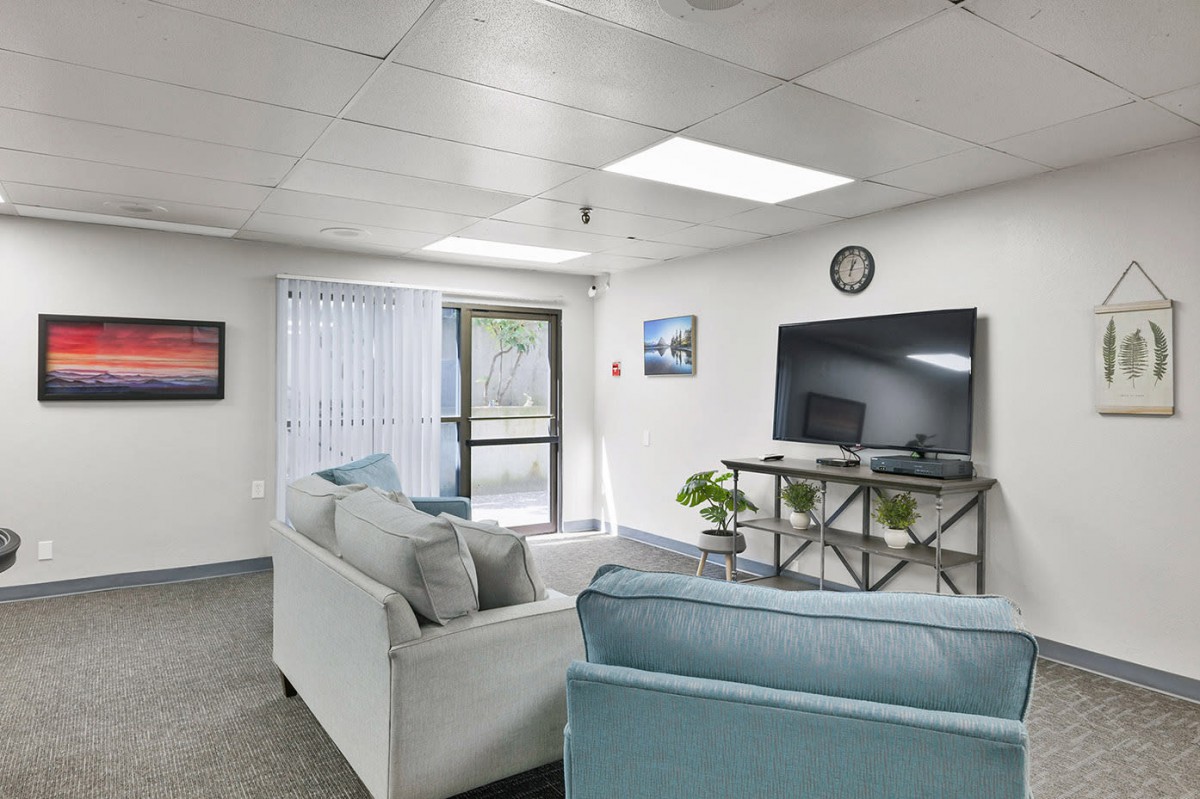 A modern living room featuring comfortable sofas, a television, and stylish decor.