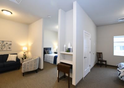 A cozy room with a bedroom and living area separated by a partition wall.