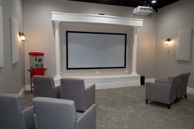 A cozy home theater setup with a projector screen and comfortable seating.