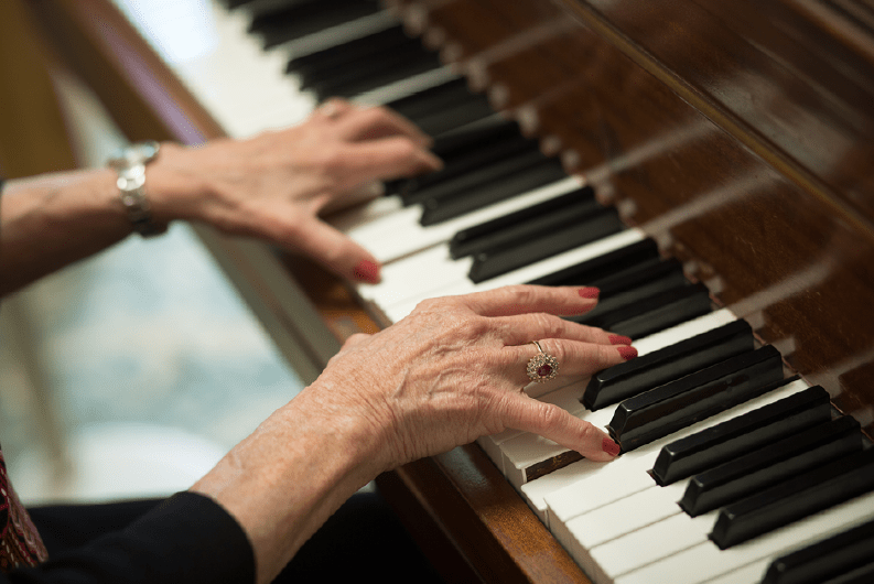 A person playing the piano with focus on their hands.
