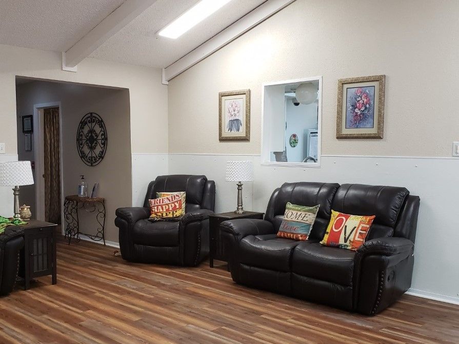 A cozy living room with leather seating and colorful pillows.