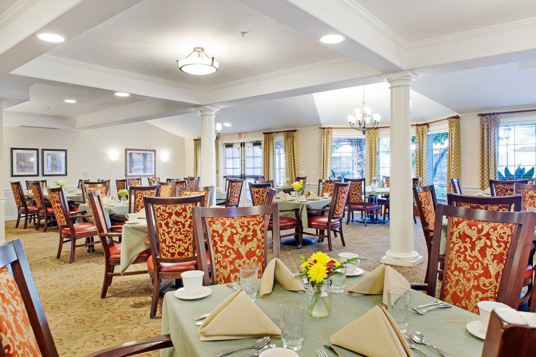 An elegantly decorated dining room with neatly set tables and comfortable chairs.