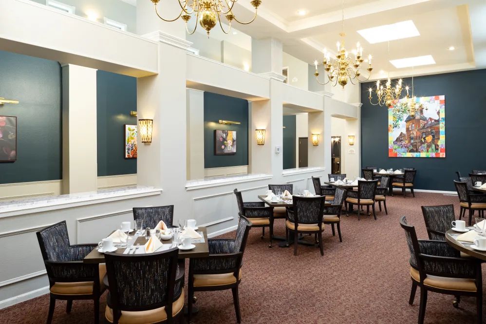 An elegant dining room with chandeliers and neatly arranged tables.