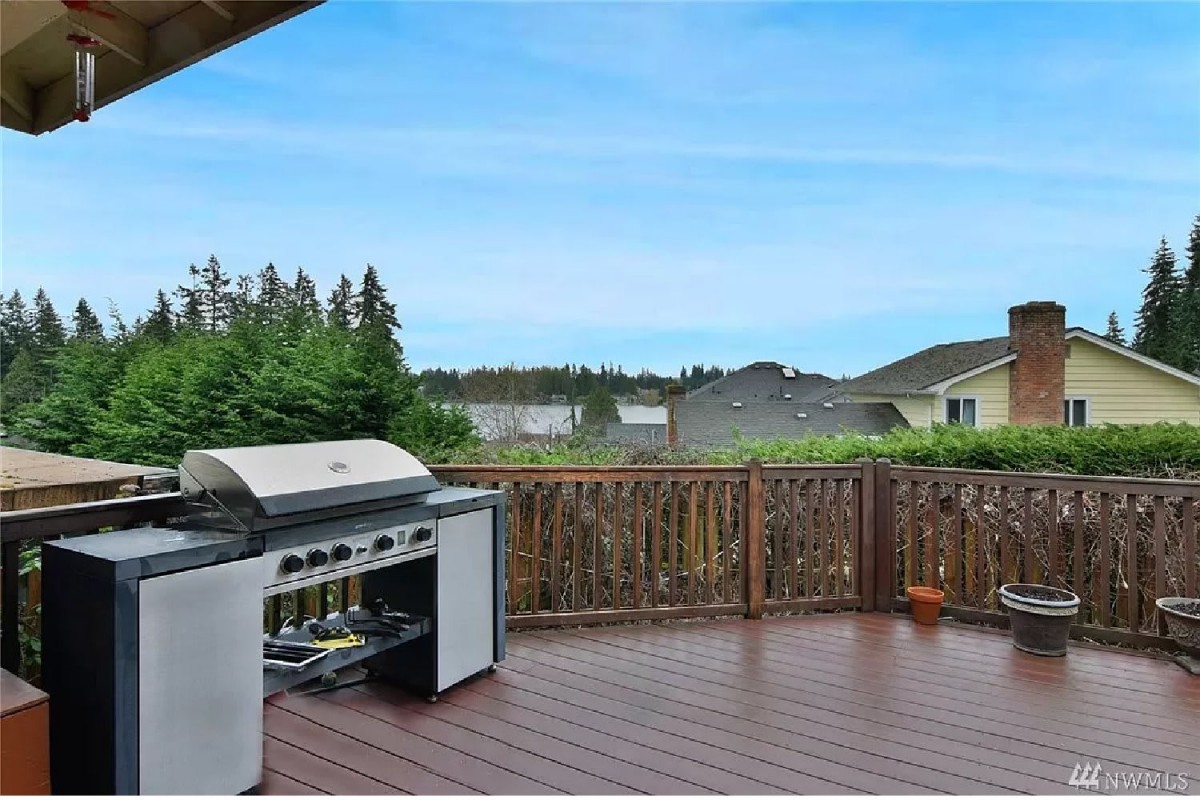 A spacious outdoor deck featuring a barbecue grill and scenic views.