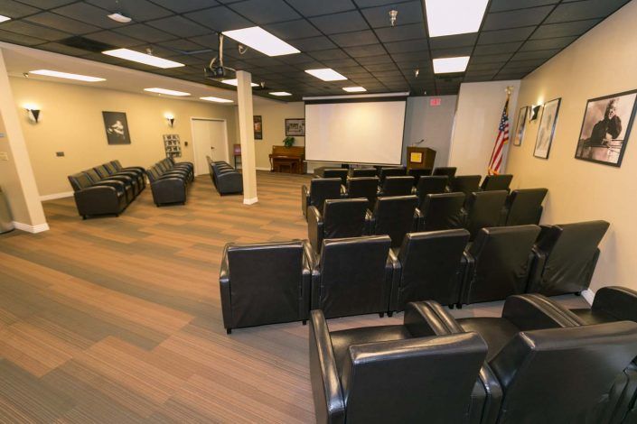 A conference room featuring arranged seating and a projector screen.