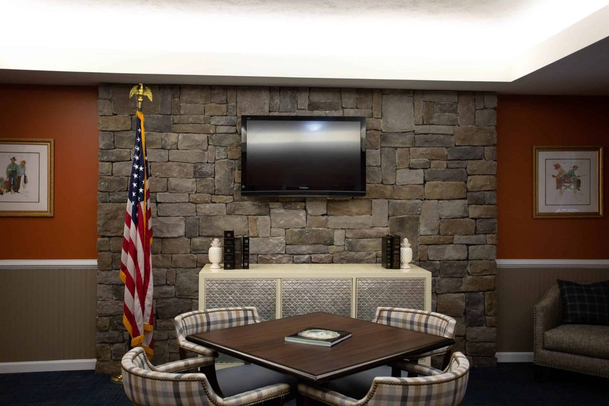 A small conference room with a table, chairs, and an American flag.