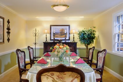 A beautifully set dining table with floral centerpiece in a tastefully decorated dining room.