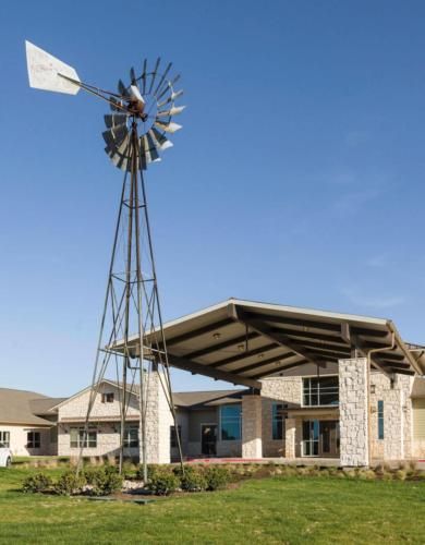 A modern building with a traditional windmill on a sunny day.