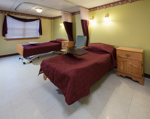 A well-appointed hospital room featuring two beds and warm lighting.