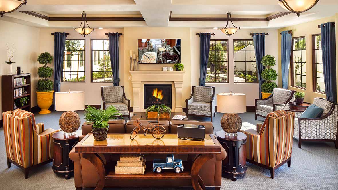 A cozy living room with elegant furnishings and a warm fireplace.