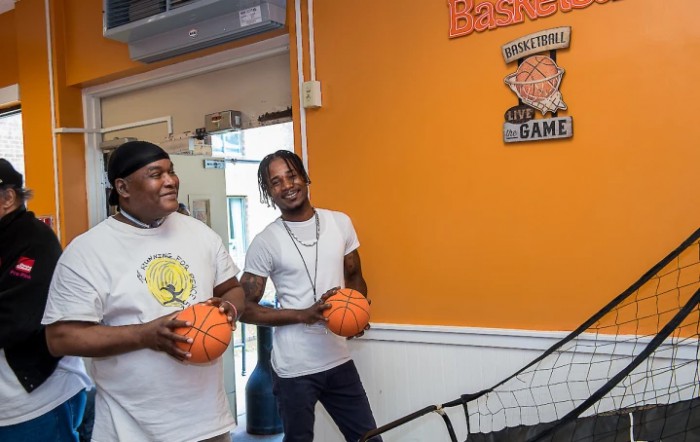 Two people enjoying a game of basketball in an indoor setting.