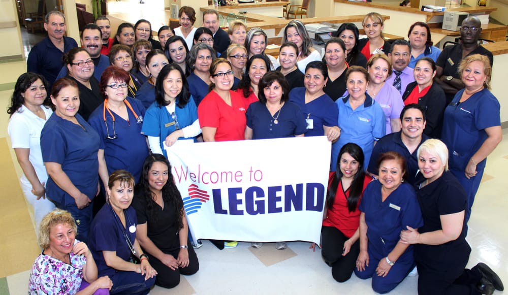 A large group of healthcare workers holding a 'Welcome to Legend' banner.