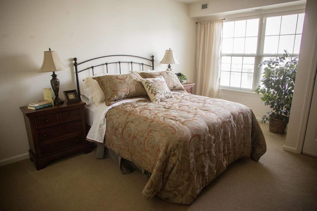 A cozy bedroom with a neatly made bed and elegant decor.