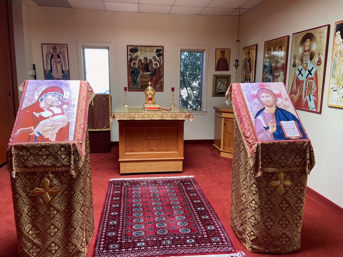 Interior view of an Orthodox church with icons and an altar.