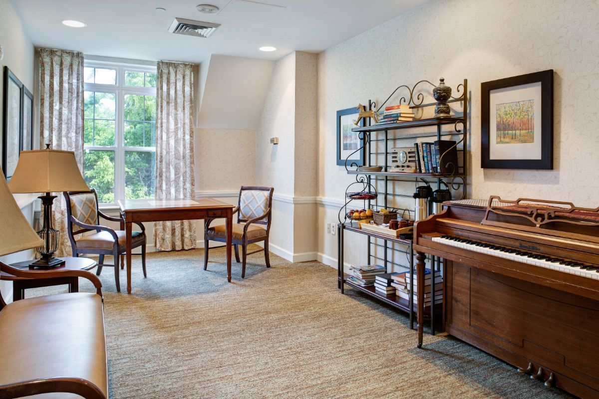 A well-lit living room with a table, chairs, and decorative shelving.
