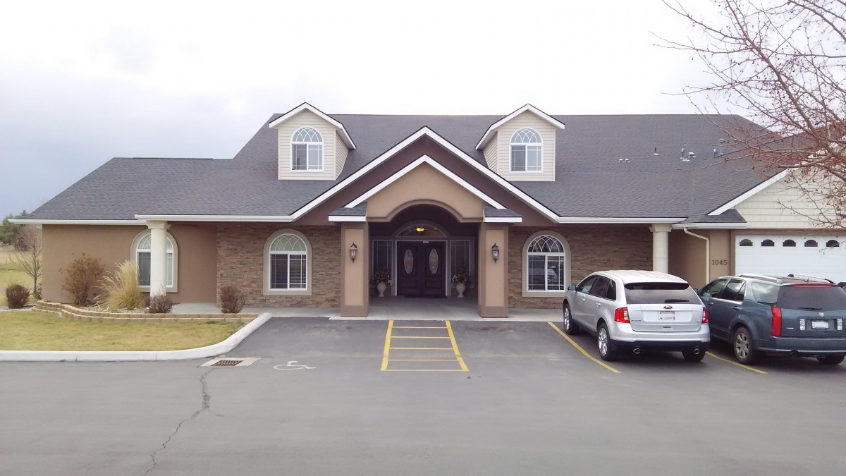 A residential building with a car parked in front.