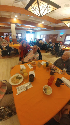 A lively gathering of seniors enjoying a mealtime together at a community center.