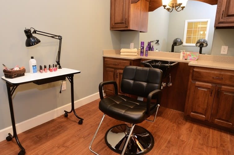 A cozy hair salon setup with a styling chair and sink, alongside a nail polish station.