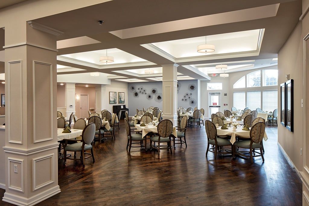 Elegant dining area with neatly arranged tables and chairs, featuring stylish interior decor and warm lighting.