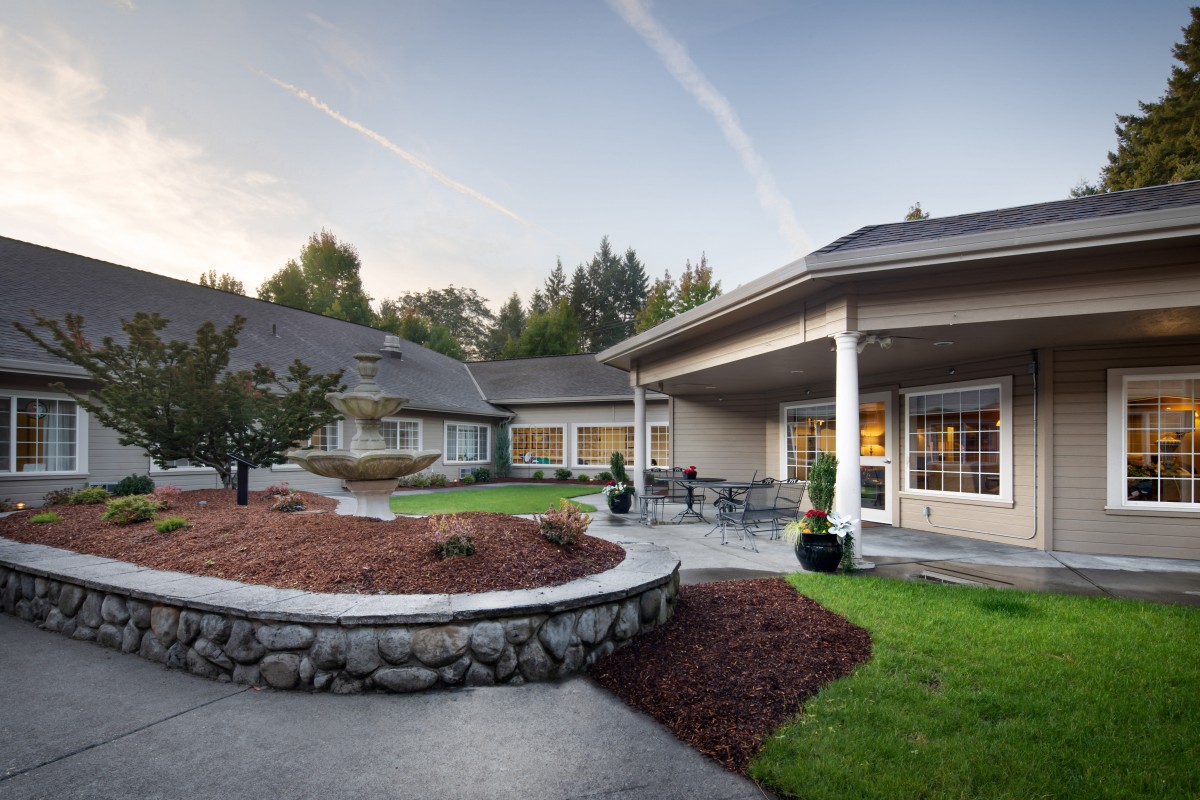A well-maintained residential building with a landscaped garden and outdoor seating area.