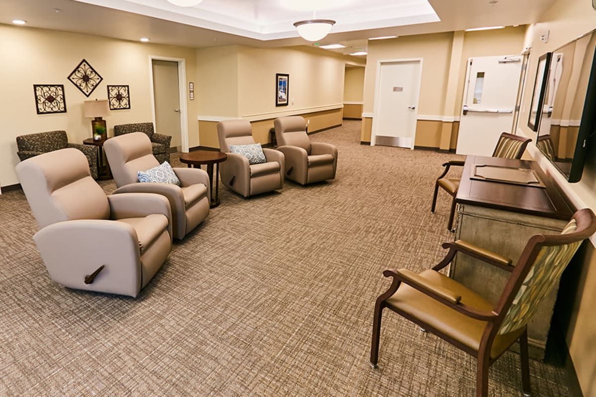 A cozy waiting room with several recliner chairs and a carpeted floor.
