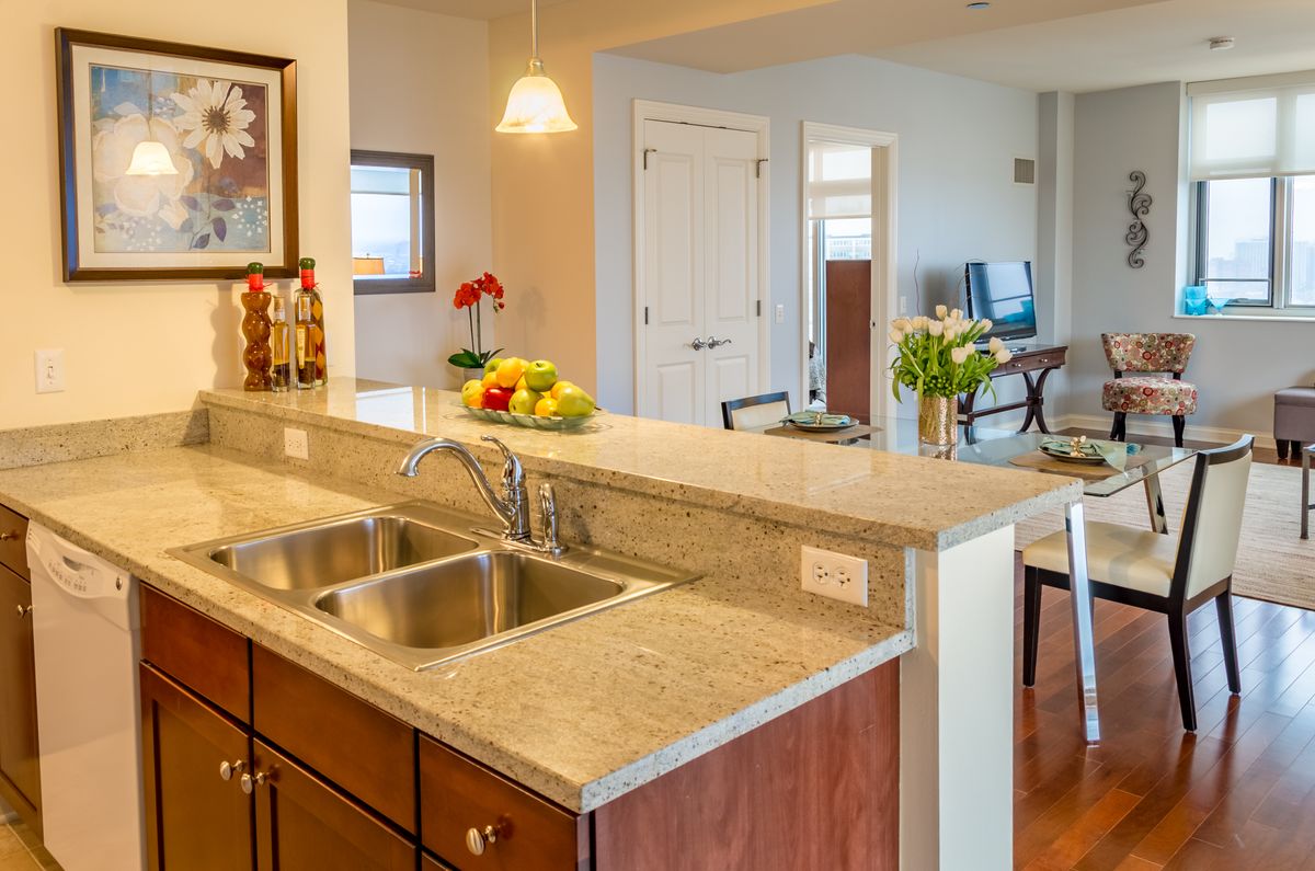 A modern kitchen with a spacious countertop and sink in an open concept home.