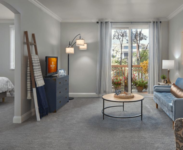 A modern living room with stylish furniture and decor, featuring a large window and soft lighting.
