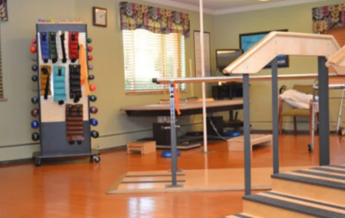 A well-equipped rehabilitation room with assorted exercise apparatus.