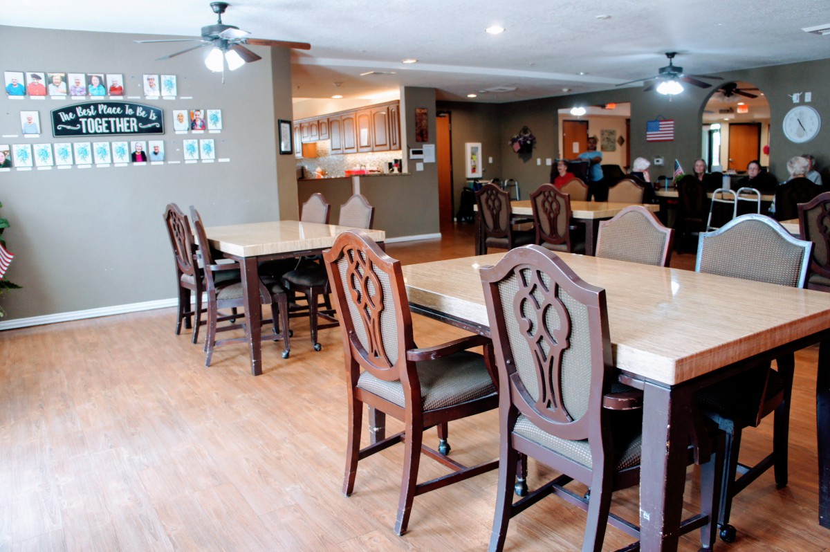 A spacious dining area with wooden tables and chairs set for guests.