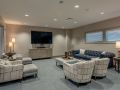 A modern living room with a large television, comfortable seating, and stylish decor.