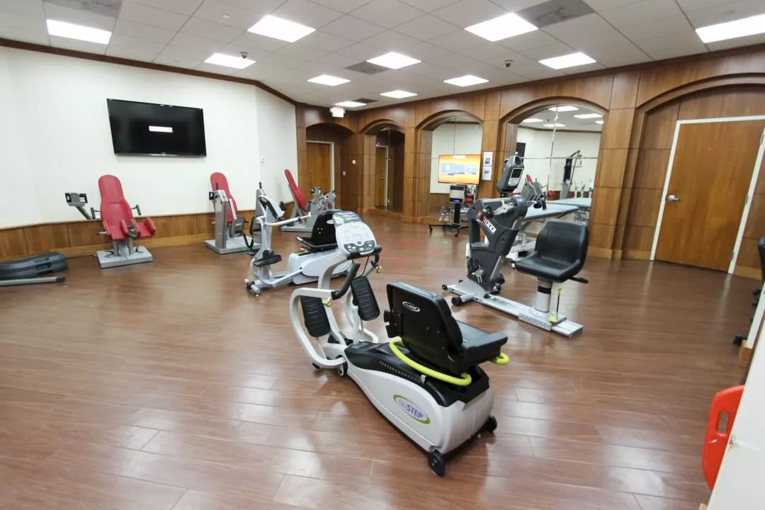 A well-equipped gym with stationary exercise bikes and wood flooring.